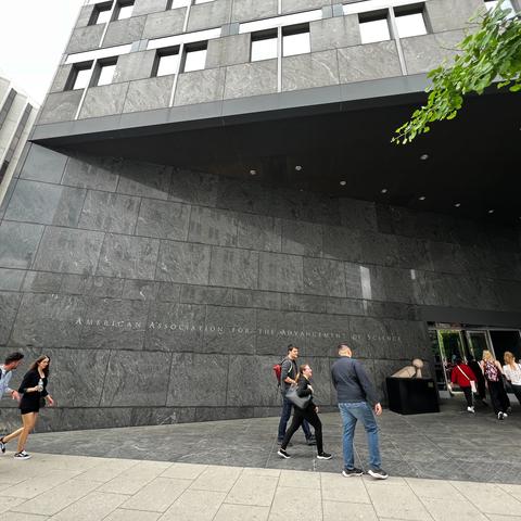 DC Trip participants walk into a building with a sign "American Association for the Advancement of Science"